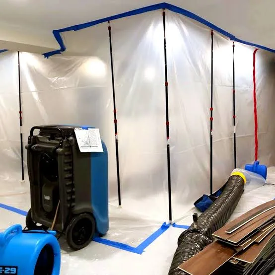 Plastic containment barrier with zip poles, a dehumidifier and air mover set up for mold remediation in a Saskatoon basement